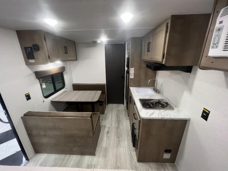 Keystone RV Springdale 1700FQ travel trailer interior with a dinette for two, kitchen, and rear bathroom.