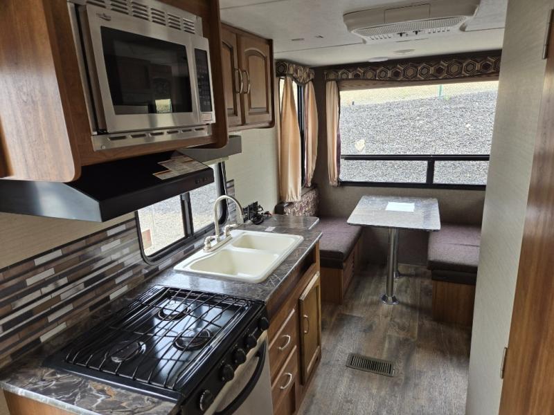 Used 2016 Keystone RV Springdale 179QBWE travel trailer interior with a kitchen and dinette